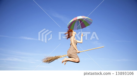 Young red-haired witch on broom flying in the sky with umbrella Young red-haired witch on broom flying in the sky with umbrella 13893106