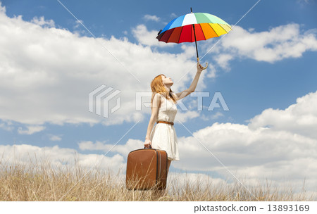 Beautiful redhead girl with umbrella and suitcase at outdoor. 13893169