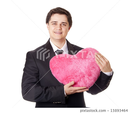 A man holding toy heart in formal black tux with tie isolated on 13893464