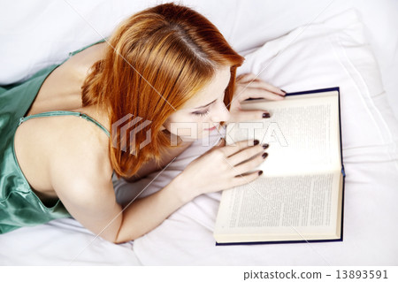 Lying girl in the bed reading book 13893591