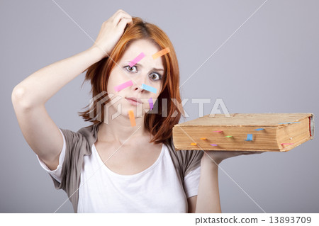 Red-haired businesswoman with book and notes on face. Red-haired businesswoman with book and notes on face. 13893709