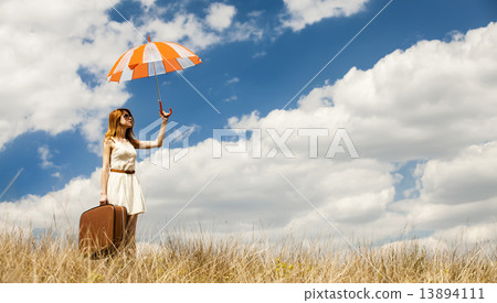 Beautiful redhead girl with umbrella and suitcase at outdoor. Beautiful redhead girl with umbrella and suitcase at outdoor. 13894111