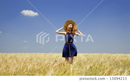 Redhead girl at spring wheat field. 13894213