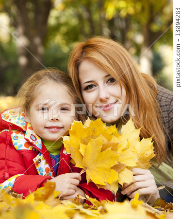Mother and daughter in autumn yellow park 13894283