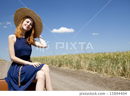 Lonely girl with suitcase at country road. 13894404