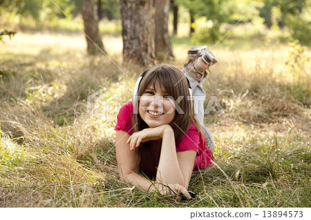 Brunette girl with headphone in the park. 13894573