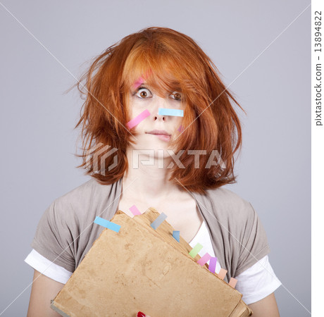 Red-haired businesswoman with book and notes on face. Red-haired businesswoman with book and notes on face. 13894822