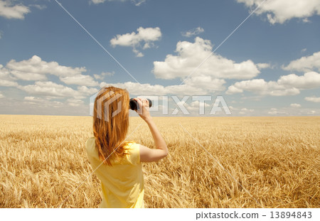 Redhead girl with binocular at wheat field. 13894843