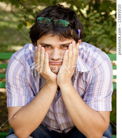 Men with glasses doing homework at the park. 13895010