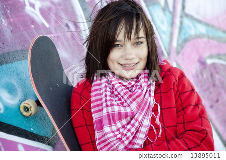 Closeup portrait of a happy young girl with skateboard and graff Closeup portrait of a happy young girl with skateboard and graff 13895011