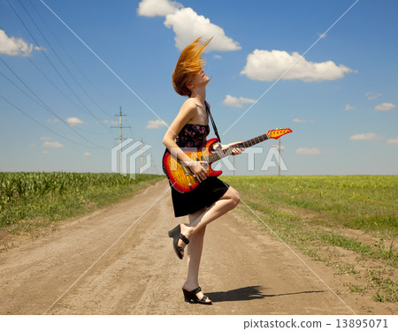 Rock girl with guitar at countryside. Rock girl with guitar at countryside. 13895071