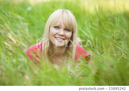 Blonde girl at green grass in the park. Blonde girl at green grass in the park. 13895242