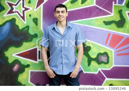 Teen boy near graffiti wall. Teen boy near graffiti wall. 13895246