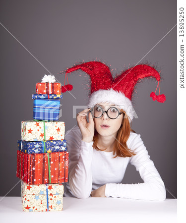 Girl in christmas cap and glasses with gift boxes. Girl in christmas cap and glasses with gift boxes. 13895250