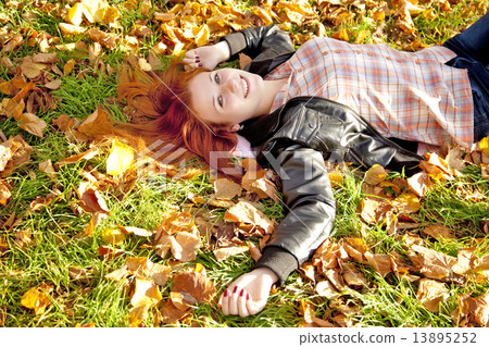 Happy red-haired girl at the park in autumn. Happy red-haired girl at the park in autumn. 13895252