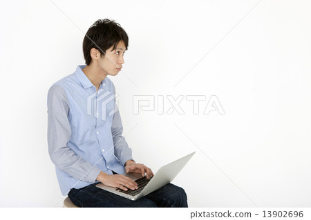 A man operating a notebook computer 13902696