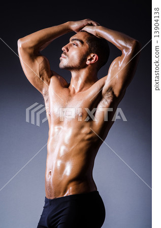 Muscular man in dark studio Muscular man in dark studio 13904138