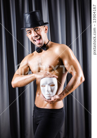 Muscular actor with mask against curtain 13904167
