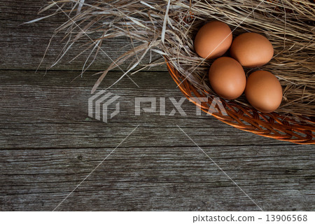 chicken eggs in straw basket on rustic wooden background chicken eggs in straw basket on rustic wooden background 13906568