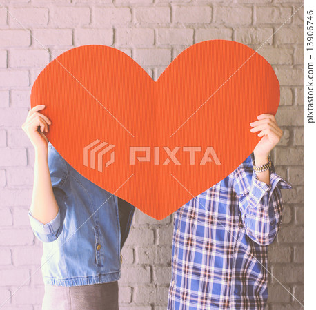 Couple holding handmade paper heart with retro filter effect Couple holding handmade paper heart with retro filter effect 13906746