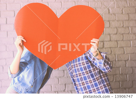 Couple holding handmade paper heart with retro filter effect Couple holding handmade paper heart with retro filter effect 13906747