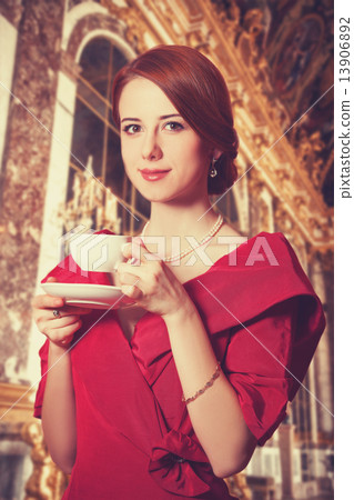 Beautiful redhead women with cup of tea. Photo in old color image style. 13906892