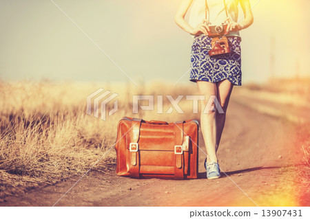 girl with suitcase and camera on country road. 13907431