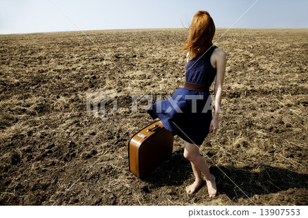 Lonely girl with suitcase at countryside field. 13907553