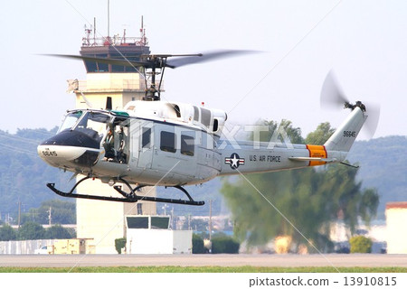 A UH-1N Iroquois utility helicopter used in disaster relief missions by the U.S. Air Force in Japan flies with the Yokota Air Base control tower in the background. 13910815