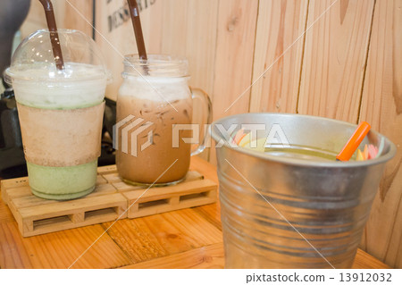 Glass of iced drink on wooden table 13912032
