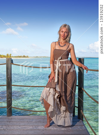 The young beautiful woman  on a wooden platform over  the sea 13919282