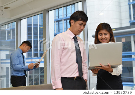 Asian business colleagues working around a laptop 13920789