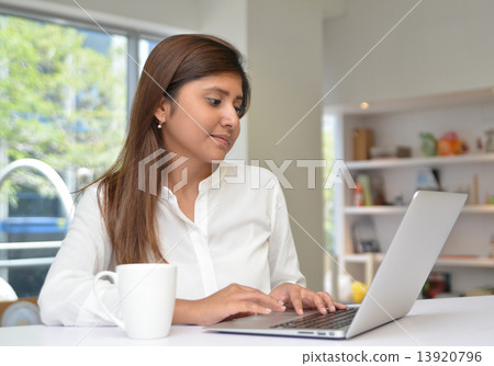 Young indian businesswoman on a coffee break. Using tablet compu 13920796