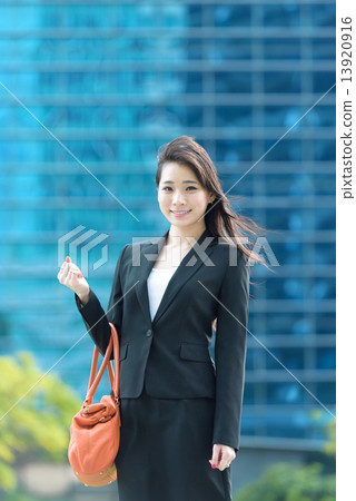 One young Chinese office lady in front of glass office building One young Chinese office lady in front of glass office building 13920916