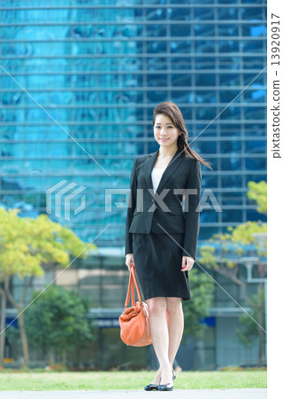One young Chinese office lady in front of glass office building One young Chinese office lady in front of glass office building 13920917