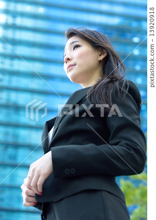 One young successful Chinese businesswoman in front of glass office building One young successful Chinese businesswoman in front of glass office building 13920918