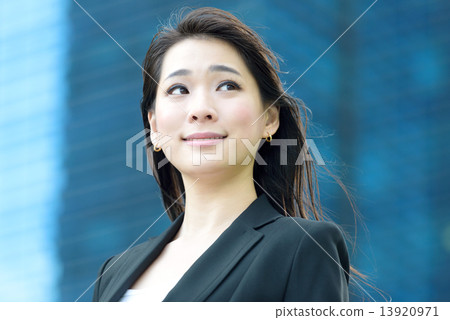 One young successful Chinese businesswoman in front of glass office building 13920971