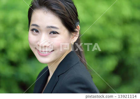 Portrait head shot of one successful chinese businesswoman in front of greenery 13921114