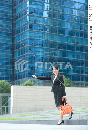 One young successful Chinese businesswoman flagging a taxi outside glass office building 13921143