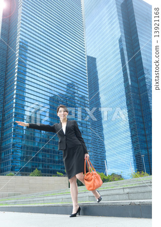 One young successful Chinese businesswoman flagging a taxi outside glass office building 13921168