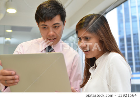 Asian business colleagues working around a laptop Asian business colleagues working around a laptop 13921564