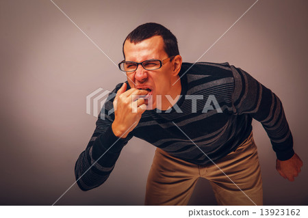 the man of European appearance brunet in a sweater put his finge 13923162