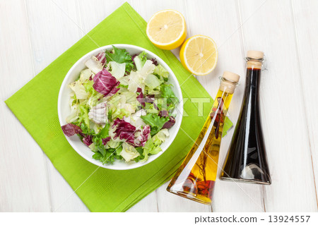 Fresh healthy salad and condiments over white wooden table 13924557