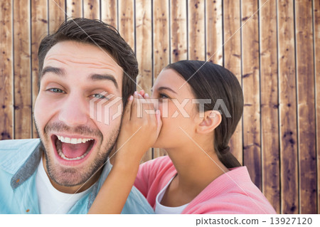 Composite image of brunette whispering secret to her boyfriend 13927120