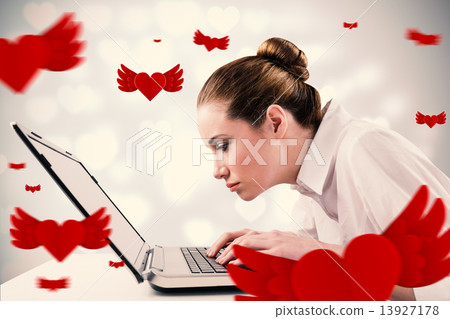 Composite image of attentive businesswoman typing on laptop 13927178