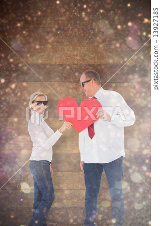 Composite image of older affectionate couple holding red heart s Composite image of older affectionate couple holding red heart s 13927185
