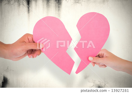 Composite image of couple holding two halves of broken heart Composite image of couple holding two halves of broken heart 13927281