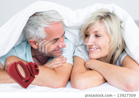 Composite image of closeup of a mature couple lying in bed 13927309