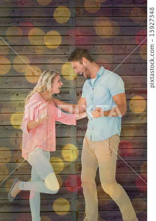 Composite image of attractive couple smiling and cheering Composite image of attractive couple smiling and cheering 13927348
