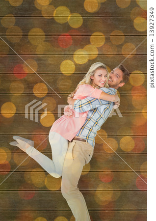 Composite image of handsome man picking up and hugging his girlf Composite image of handsome man picking up and hugging his girlf 13927349